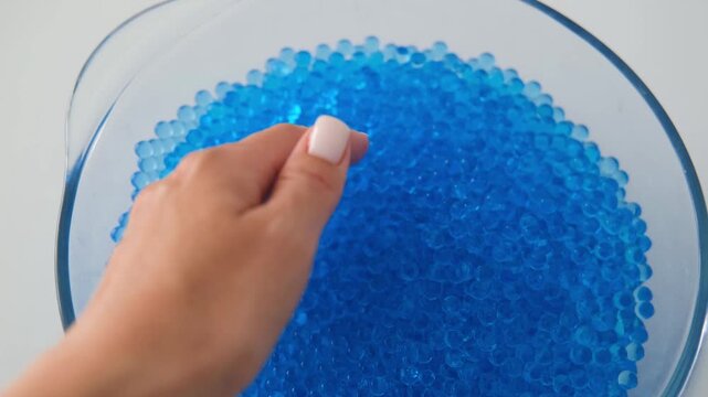 Women's hands playing with blue orbeez balls