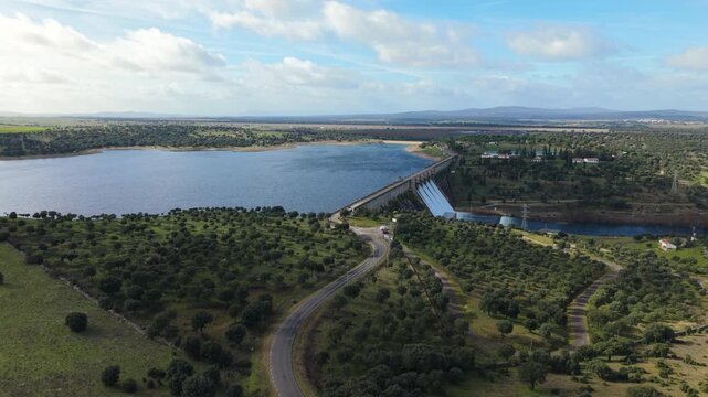 Scenic aerial drone shot of the Santa Teresa Reservoir dam releasing water into the Tormes River for hydroelectric power in Salamanca, Castilla y Leon, Spain