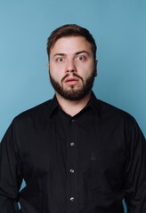 Obraz premium Man with surprise expression stands against blue background