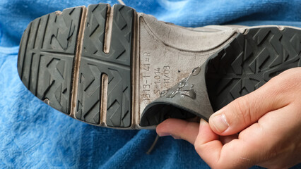 A male hands repair shoes glueing the rubber sole of a sneaker with glue. Favorite shoes. The...