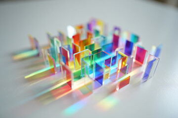 Colorful crystal prisms on white surface with rainbow light reflections