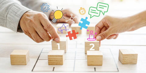 Business strategy concepts and planning in teamwork with hands stacking wooden blocks with business icons