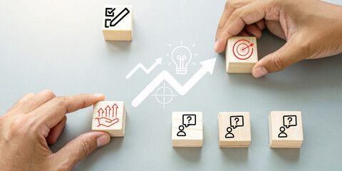 Business growth Concept and planning for success with hands holding wooden blocks featuring icons related to business investment goals