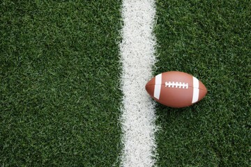 Obraz premium American football on green field with white line
