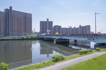 大規模な集合住宅と大きな橋がかかる河川敷の広がり