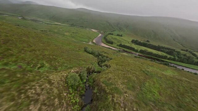 Aerial view of meandering river in green highland valey