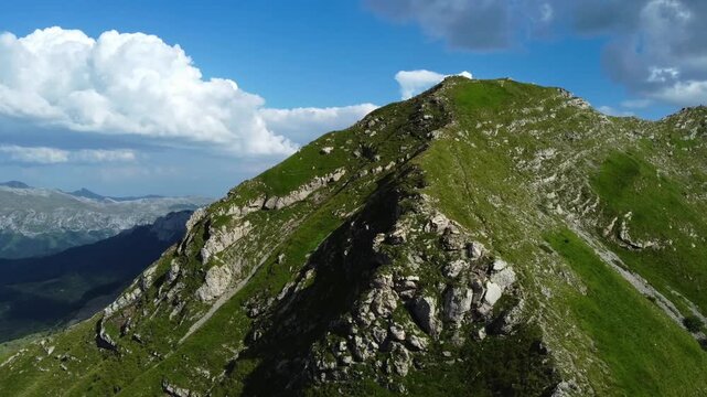 Aerial view of majestic green mountain peak against lue sky