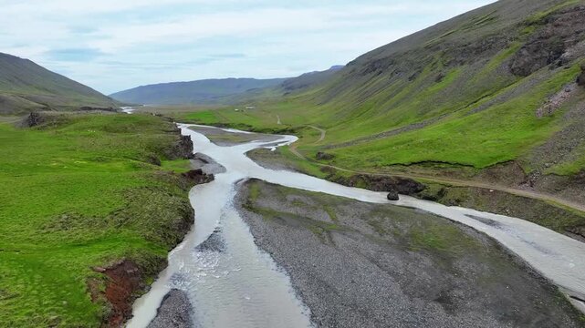 Aerial view of glacial river flowing through green cayon
