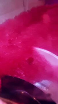 Pink slushie machine mixing cold frozen drink