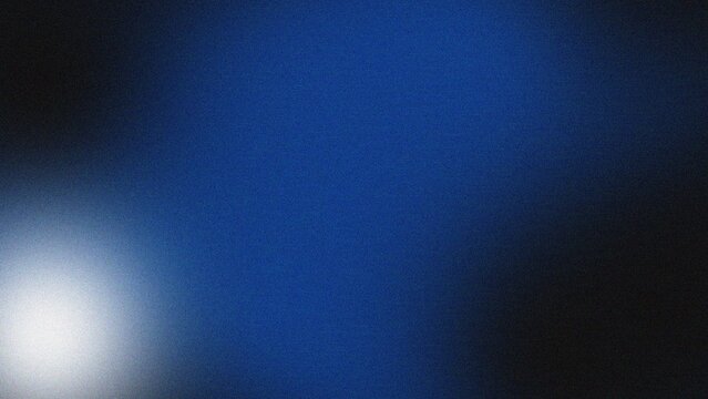 Blurry blue light spot on dark background viewed from a close-up perspective as a photographic image