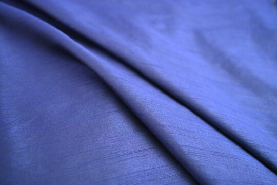 Soft folds of luxurious blue fabric texture