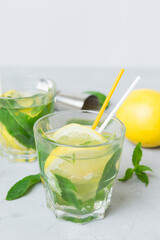 Fototapeta premium Mojito cocktail. Refreshing mojito cocktail with lime, lemon and mint in a tall glass with a stick