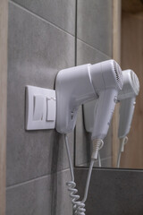 Wall mounted hair dryer in modern hotel bathroom