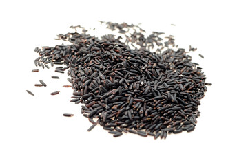 Black rice grains scattered on a white surface, showcasing their elongated shape and dark color, highlighting the unique texture and appearance of this ancient grain variety