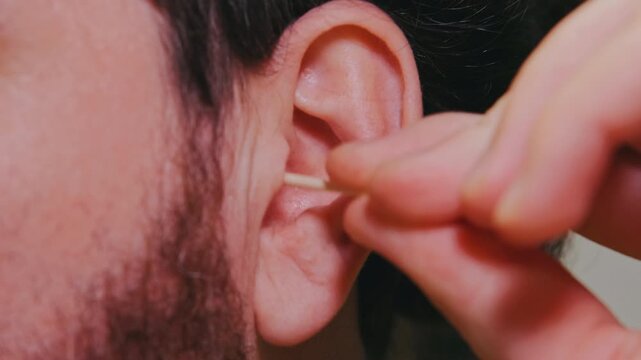 White Man Inserting Plug Into Ear, Closeup Beard And Fingers Adjusting Silicone Device, StepByStep Fitting For Comfort And Noise