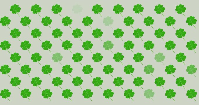 Digital animation of multiple clover leaves flickering against grey background