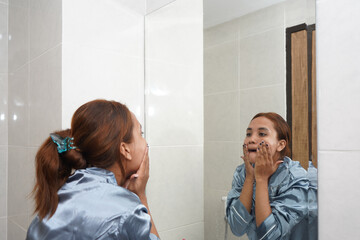 Woman Massaging Her Face While Applying Moisturizer