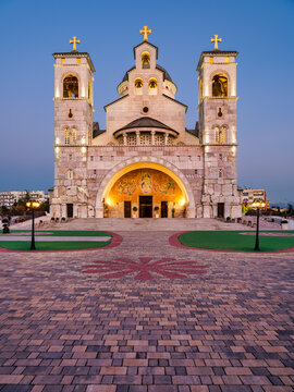 Vertical view of the illuminated twin towers and stone facade of the Cathedral of the Resurrection of Christ at night in Podgorica, Montenegro.