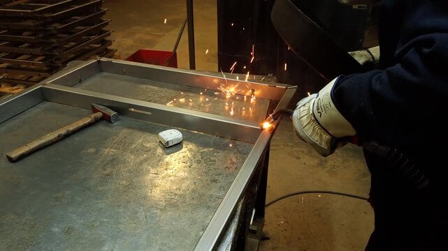 Precision laser welding of a metal frame in a modern industrial workshop.