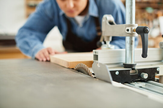 Talented young woman focuses intently on her craft in a lively workshop filled with tools.