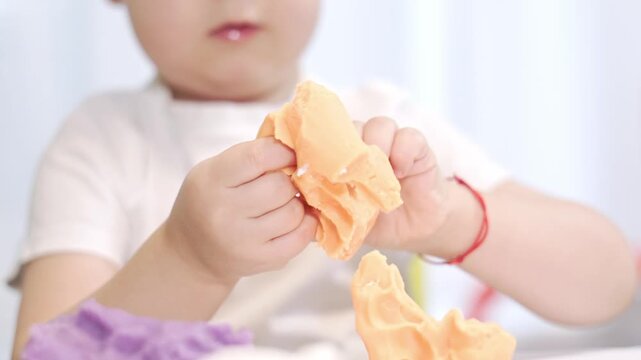 Toddler hands playing with modeling clay
