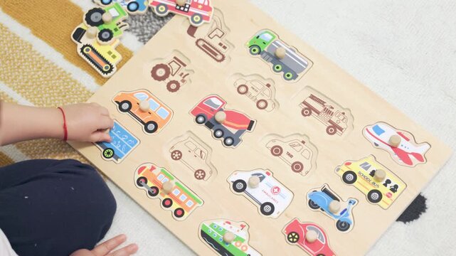 Toddler boy playing with a wooden vehicle puzzle