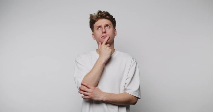 Man shows different facial expressions and gestures while thinking in a studio setting