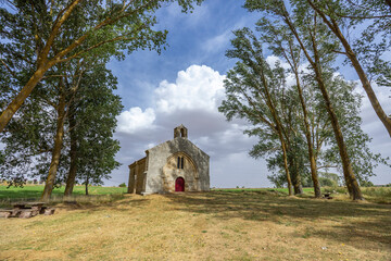 Ancient hermitage standing among trees under a cloudy sky