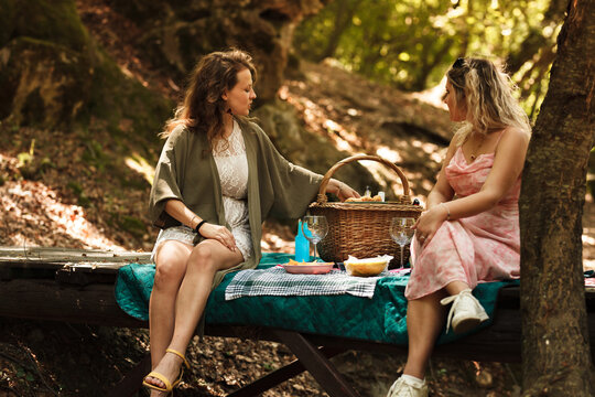 Enjoying a summer picnic in a lush forest with friends and delicious food