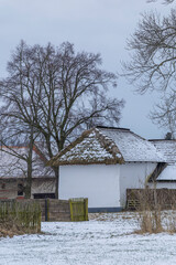 Traditional cottage experiencing winter snow in Rymice