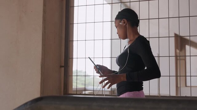Woman simulating speech. Young lady preparing her speech. Young woman rehearsing speech using gestures by window. Girl meticulously practicing her speech and gestures in front of window