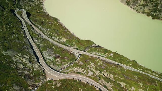 Popular mountain pass in Swiss Alps with winding car road, top view. Grimselpass