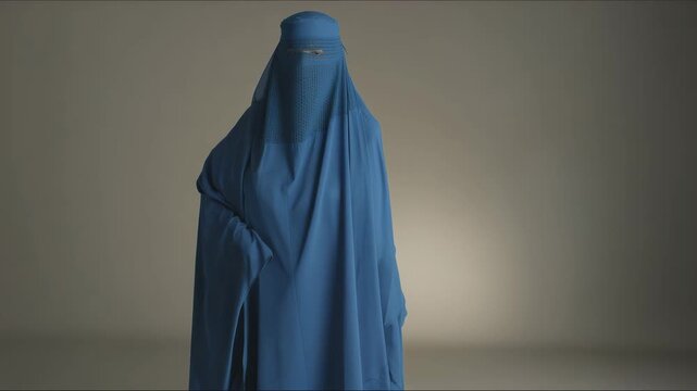 woman in full traditional blue burqa standing still, close-up rear framing emphasizing handcrafted textile patterns and mesh eye panel, soft vignette 4K