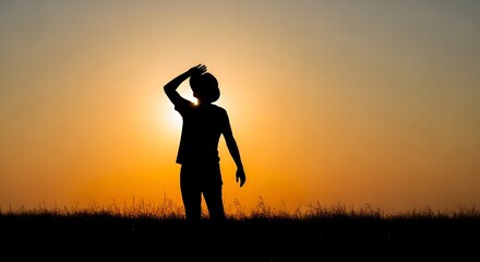 Silhouette of a person standing against a vibrant sunset