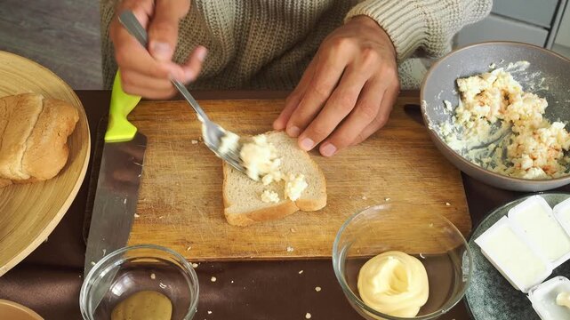 a man making egg sandwiches for breakfast