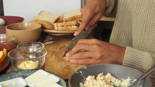 a man making egg sandwiches for breakfast