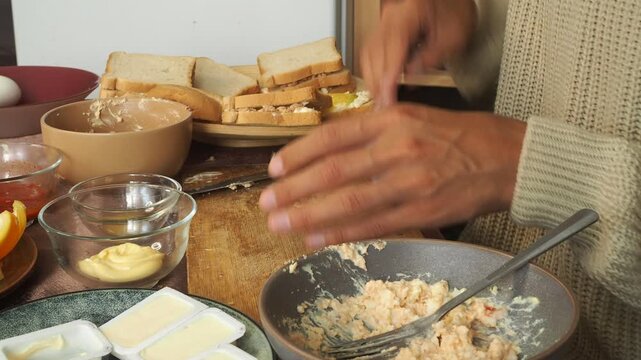 a man making egg sandwiches for breakfast