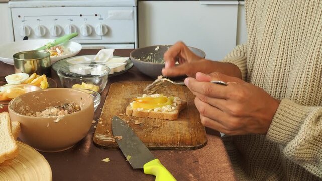 a man making egg sandwiches for breakfast