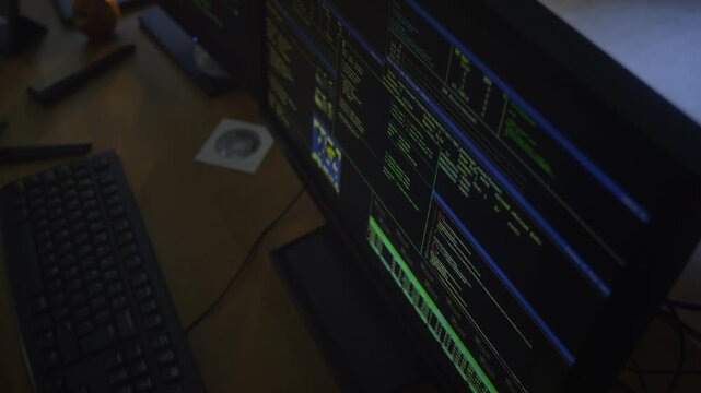 Close up shot of desktop computer screen displaying malware code, private hacker workspace in dark office