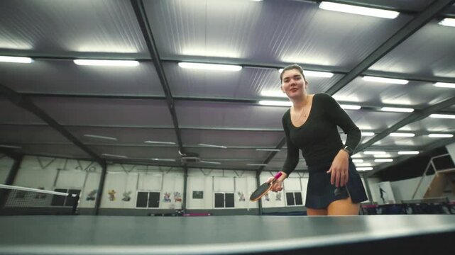Woman making funny face playing table tennis