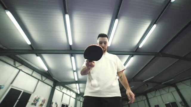 Low angle of man bouncing ping pong ball