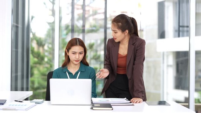 Chief and subordinate talking at workplace, dissatisfied boss points on mistakes on report criticizing work scolding accusing young female employee.