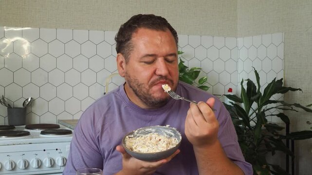 a grown man is having lunch in the kitchen