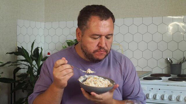a grown man is having lunch in the kitchen