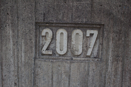 Number 2007 engraved on rough gray concrete wall texture