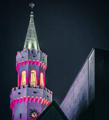 Zbliżenie na podświetloną wieżę ratusza w Opolu nocą, z dekoracyjnymi iluminacjami na pierwszym planie, prezentujące neorenesansową architekturę wzorowaną na florenckim stylu © Henryk Niestrój