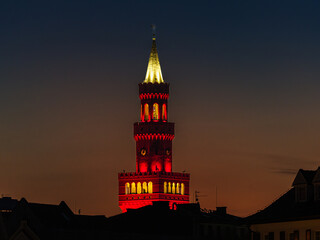 Zbliżenie na podświetloną wieżę ratusza w Opolu nocą, z widocznym księżycem i świątecznymi iluminacjami, prezentujące neorenesansową architekturę wzorowaną na stylu włoskim. © Henryk Niestrój