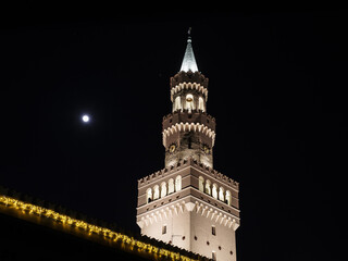 Zbliżenie na podświetloną wieżę ratusza w Opolu nocą, z księżycem w tle i dekoracyjnymi iluminacjami na pierwszym planie, prezentujące neorenesansową architekturę wzorowaną na florenckim stylu © Henryk Niestrój