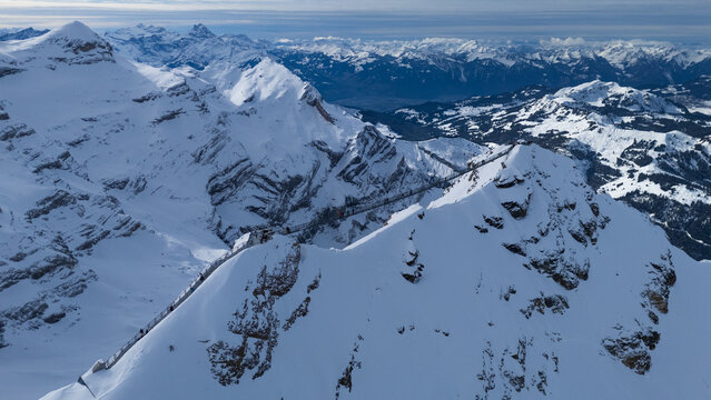 Winter photo of Glacier 3000 in Switzerland, showcasing snow-covered peaks, icy glaciers, and dramatic alpine scenery under a clear mountain sky