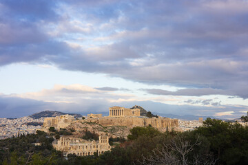 Fototapeta premium The Acropolis and Parthenon in Athens, at sunset, Greece. Bathed in the light of the setting sun against a backdrop of picturesque clouds, the Acropolis looks majestic and grandiose. 